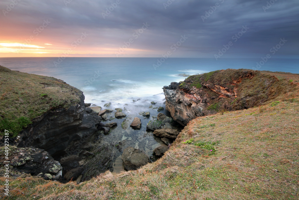 a rocky hillside next to a body of water a rocky hillside next to a body of water