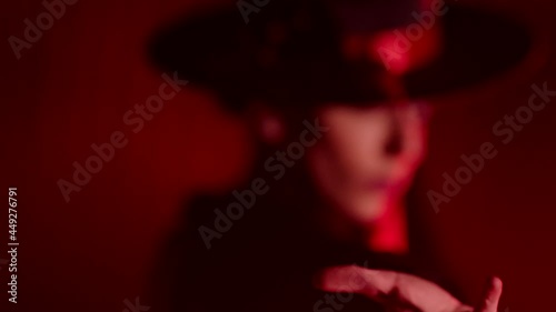 Beautiful hat dressed girl dancing latin dance . Professional female dancer dancing flamenco , rumba or salsa on red background with lines . Spanish dance movements . Shot ARRI ALEXA Cinema Camera .