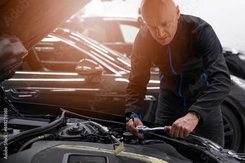 Man car mechanic repairing car with wrench in service