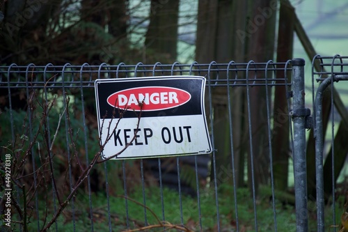 Warning sign on metal fence