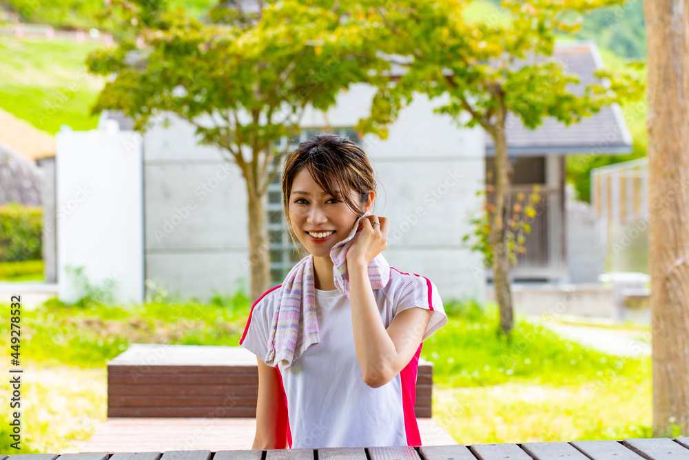 休憩所で汗を拭く笑顔の女性