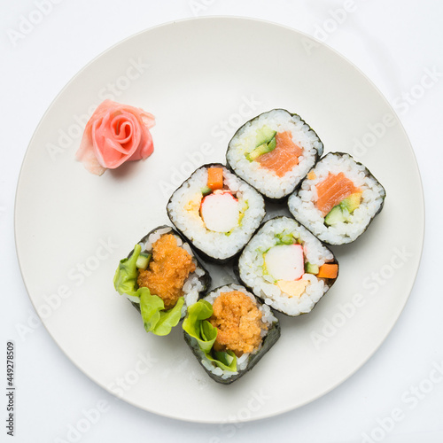 Mixed salmon Sushi rolls on plate decoraded with marinated ginger