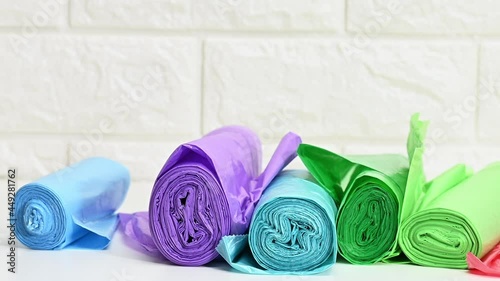 falling twisted transparent polyethylene trash bags on white table, slow motion
