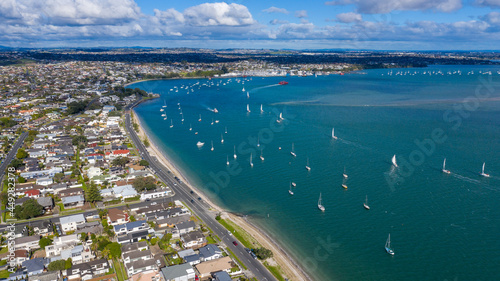 Fototapeta Naklejka Na Ścianę i Meble -  Aerial View from the Beach, Green Trees, City Streets and Waves - Tahuna Torea, Bucklands Beach View in New Zealand - Auckland Area