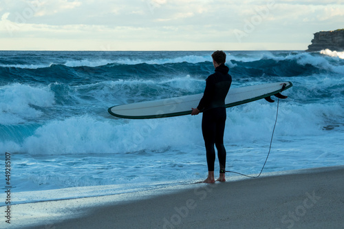 surfer on the beach checking out the surf, surfer about to go surfing
