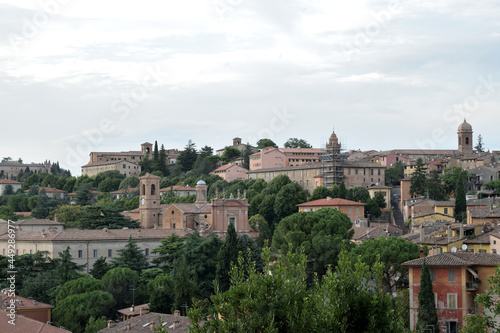 scenery view of old houses in a town with a trees and part o in the back , italy , perugia city .
