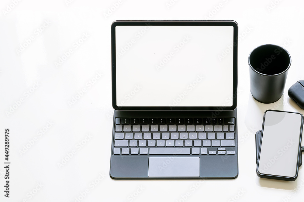Mockup blank screen tablet and smartphone on white table, black and white color design. Mockup blank screen tablet and smartphone on white table, black and white color design.