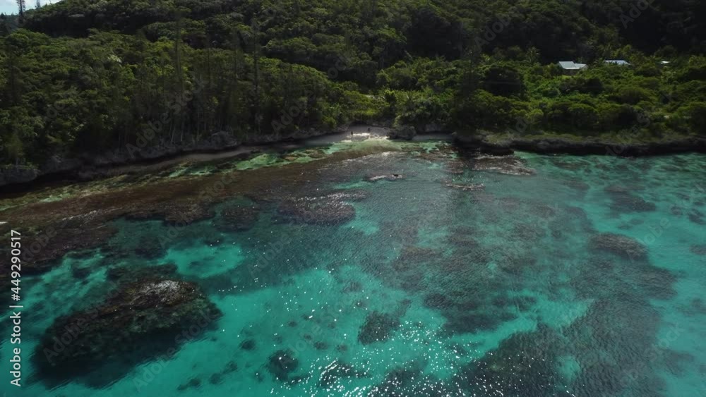 Aerial view away from coral reefs, revealing the coastline of the Mare island, in New Caledonia - pull back, pan, drone shot Aerial view away from coral reefs, revealing the coastline of the Mare island, in New Caledonia - pull back, pan, drone shot