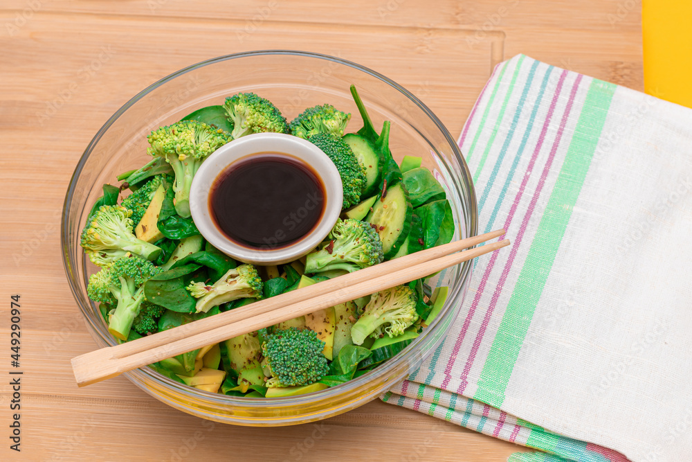 Fresh Green Salad of Avocado, Broccoli, Spinach and Cucumber for Detox with Soy Sauce on Wooden Cutting Board. Vegan Salad. Vegetarian Culture. Raw Food. Healthy Eating and Vegetable Diet Fresh Green Salad of Avocado, Broccoli, Spinach and Cucumber for Detox with Soy Sauce on Wooden Cutting Board. Vegan Salad. Vegetarian Culture. Raw Food. Healthy Eating and Vegetable Diet