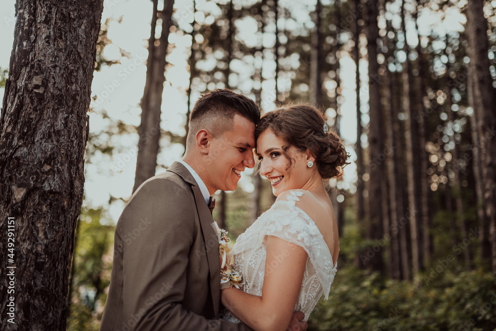 luxury stylish young bride and groom in the background spring sunny green forest. Couple in love. High quality photo. Selective focus 