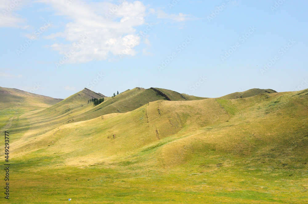 Low mountain range with ribbed hills in the summer steppe.