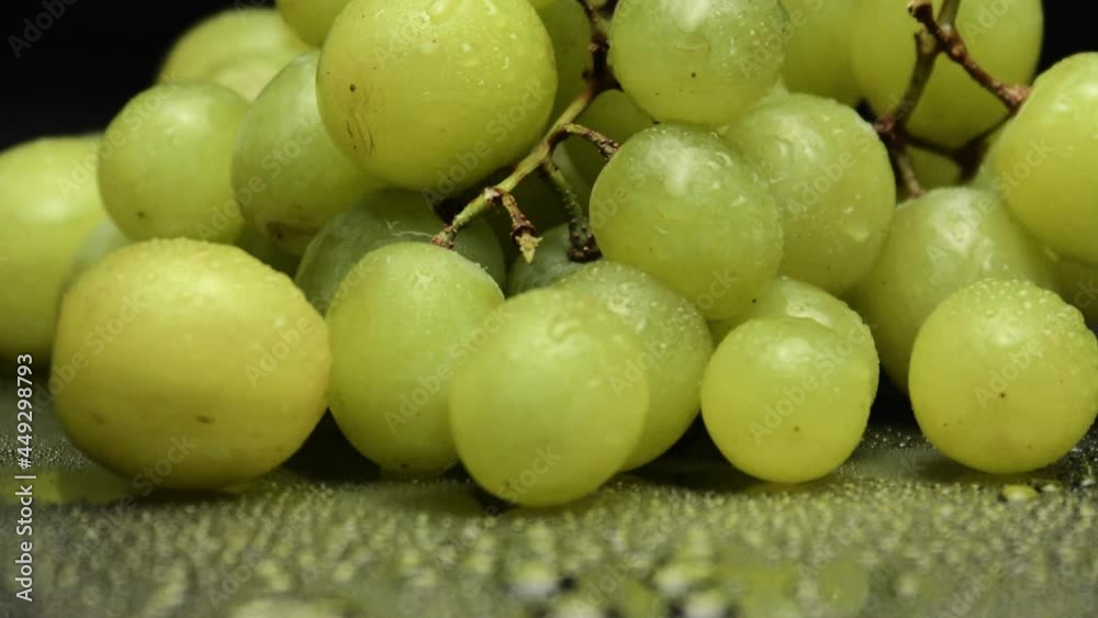 Bunch of delicious green grapes isolated on black background. Tilting up view Bunch of delicious green grapes isolated on black background. Tilting up view