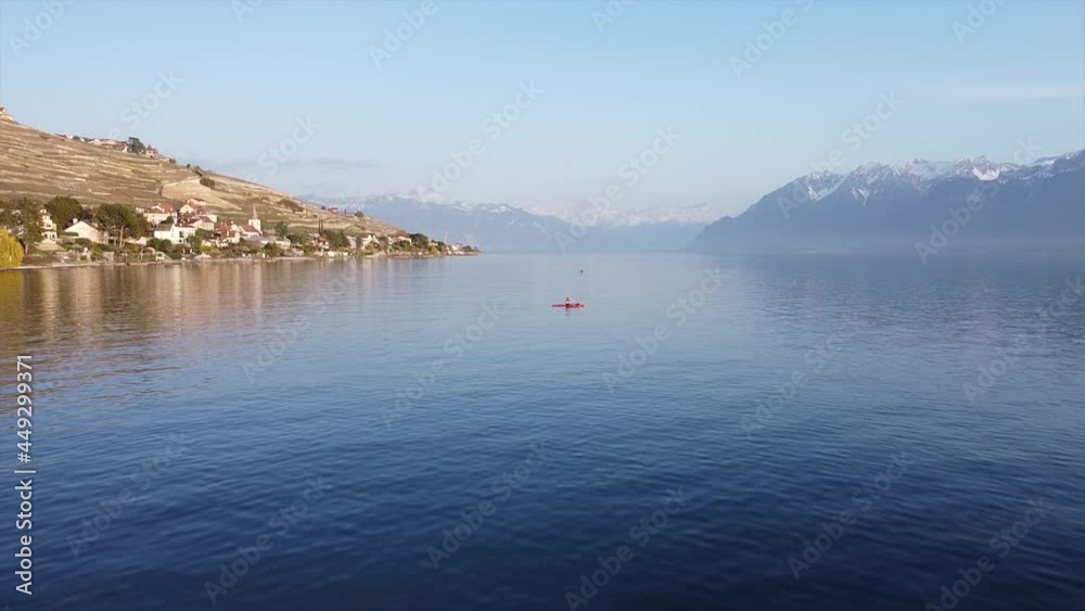 Aerial subject and orbit shot of a person on a red kayak on Lake Geneva near Lutry, Switzerland on a sunny day. Aerial subject and orbit shot of a person on a red kayak on Lake Geneva near Lutry, Switzerland on a sunny day.