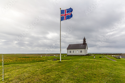 strandarkirkja church with a flag on a cloudy day in Iceland