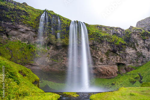 Typical landscape for the summer in Iceland. At the foot of the waterfall Seljalandsfoss crowds of tourists