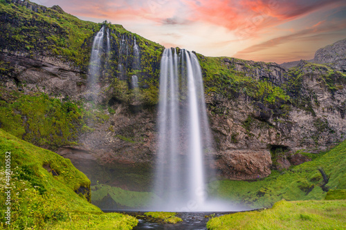 Typical landscape for the summer in Iceland. At the foot of the waterfall Seljalandsfoss crowds of tourists