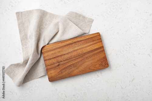 Fotografi Wooden cutting board with linen napkin on marble table