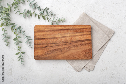 Wood cutting board with linen napkin and plant photo