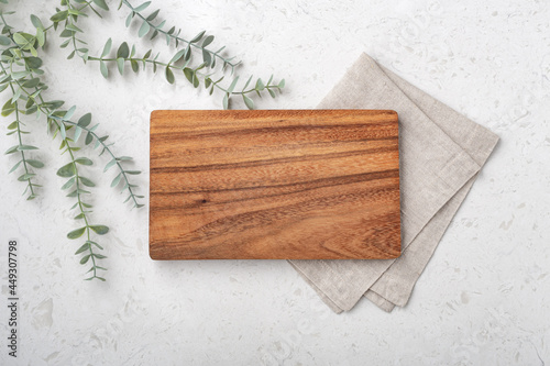 Фотография Wood cutting board with linen napkin and plant