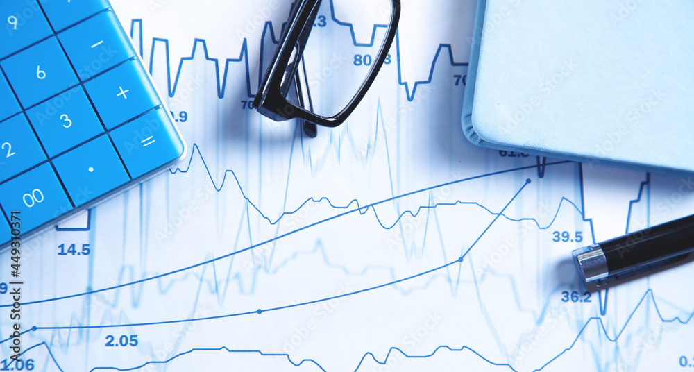 Calculator, pen, eyeglasses on financial graphs. Business. Analysis Calculator, pen, eyeglasses on financial graphs. Business. Analysis