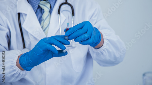 medical or scientific researcher researching and experimenting Multi-colored solution, vial and microscope In the laboratory or in the laboratory by wearing blue gloves and white clothing completely.