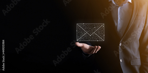 Businessman hand holding e-mail icon, Contact us by newsletter email and protect your personal information from spam mail. Customer service call center contact us concept