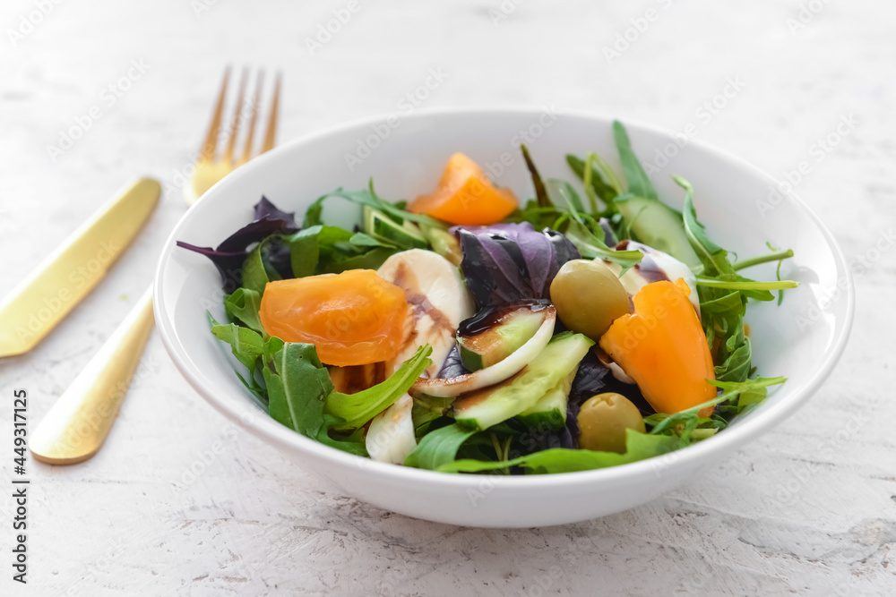 Bowl with tasty fresh salad on light background, closeup Bowl with tasty fresh salad on light background, closeup