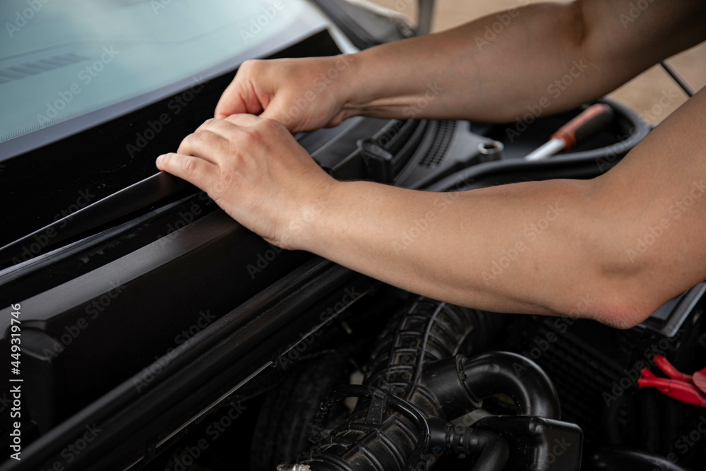 a man repairs a car. a man in blue special clothes to repair the car. engine parts machine repair maintenance breakage problem hands people man master