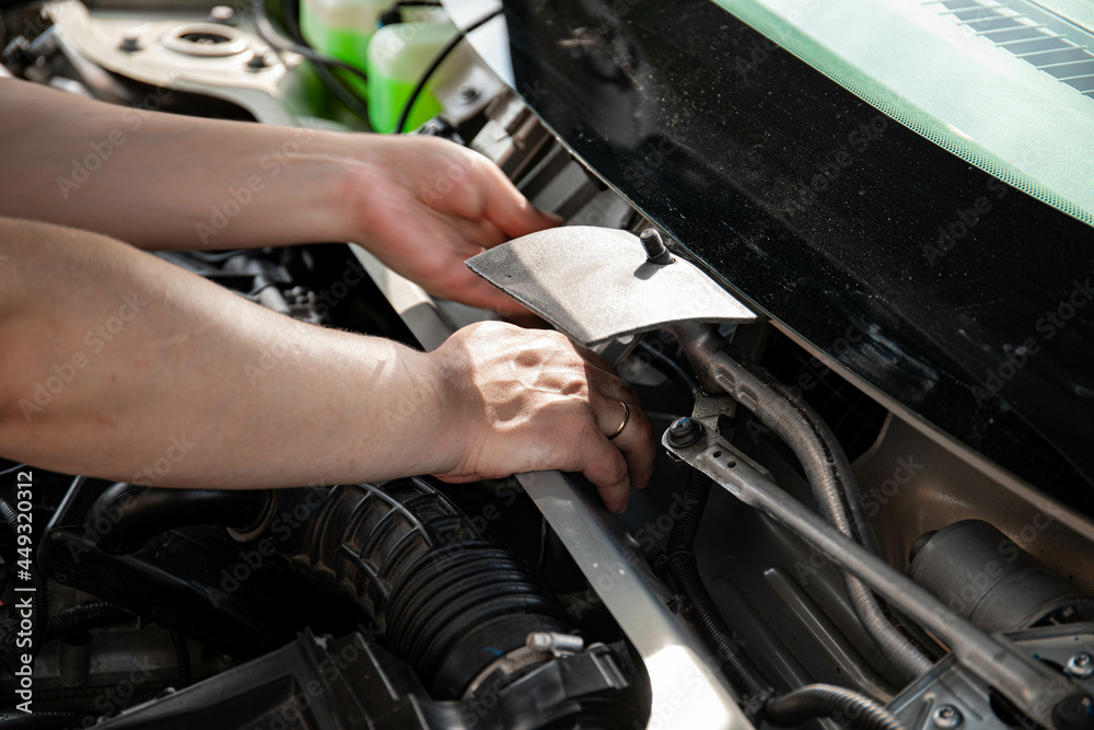 a man repairs a car. a man in blue special clothes to repair the car. engine parts machine repair maintenance breakage problem hands people man master a man repairs a car. a man in blue special clothes to repair the car. engine parts machine repair maintenance breakage problem hands people man master