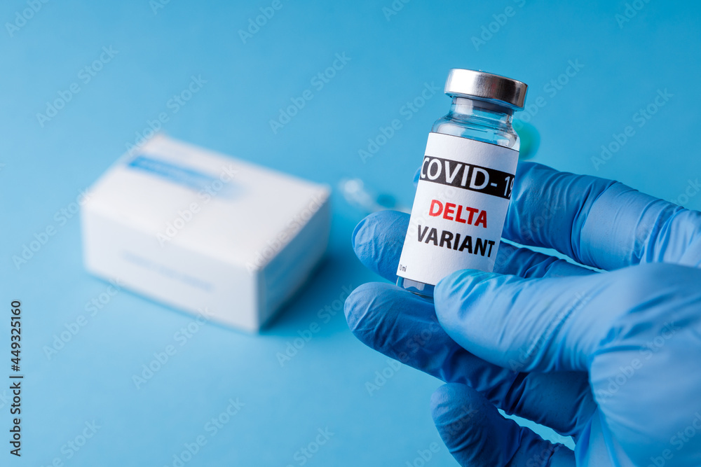 Female doctor holding syringe and COVID-19 delta variant vaccine
