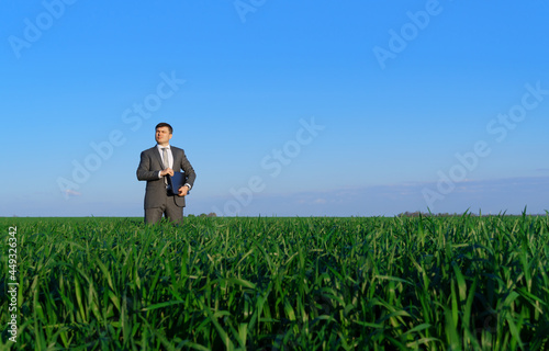 businessman works in a green field  freelance and business concept  green grass and blue sky as background