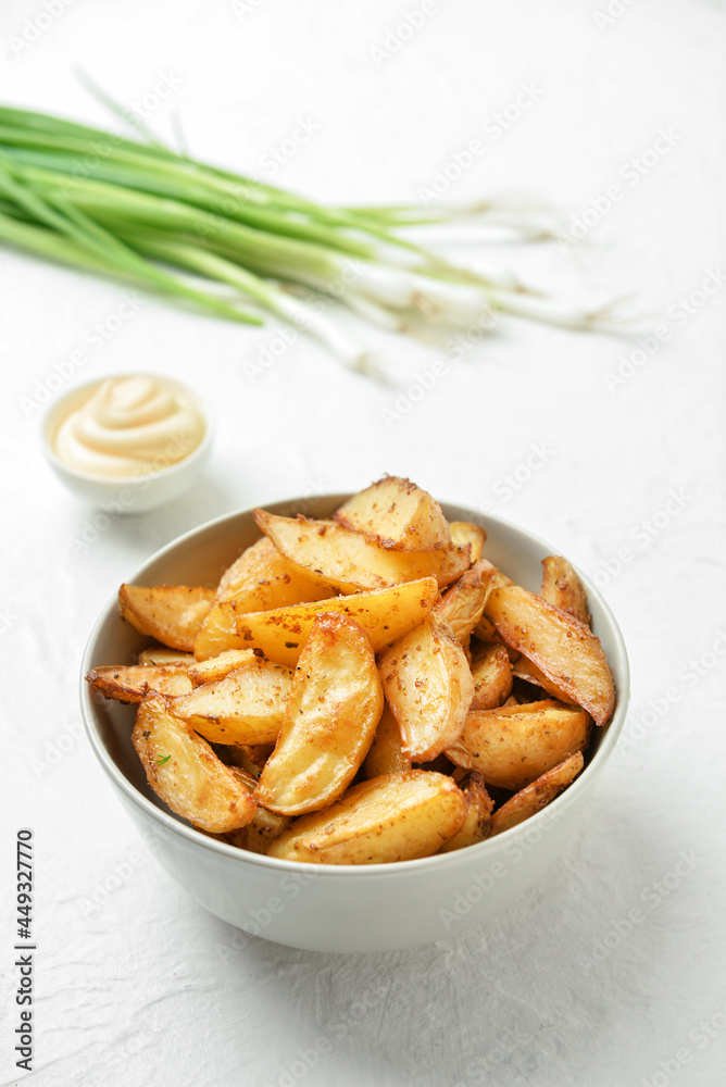 Bowl with tasty baked potato on light background Bowl with tasty baked potato on light background