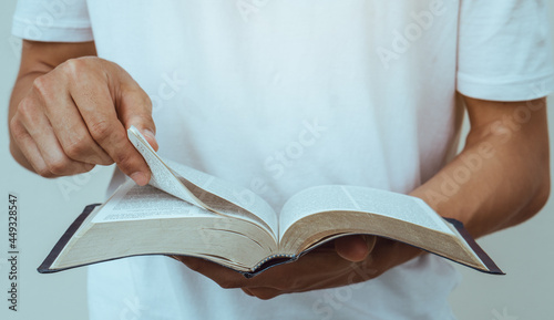 close up young man reading the holy bible.