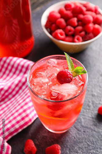 Glass of tasty raspberry lemonade on dark table