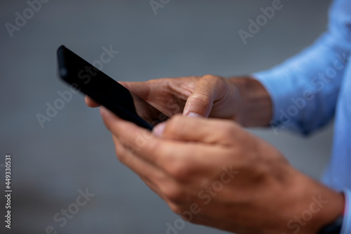 Close up of businessman using the phone. Young manager typing a message