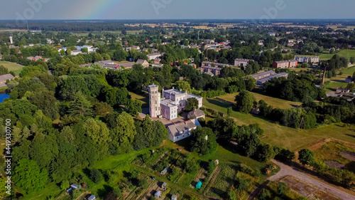 Vecauce Manor in Latvia Aerial View of the Pink Castle Through the Park. Vecauce Castle Tower With a Flying Latvian Flag. View From Above.