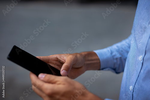 Close up of businessman using the phone. Young manager typing a message