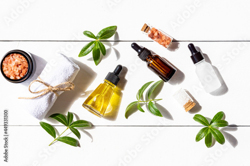 Fototapeta Naklejka Na Ścianę i Meble -  Top view of face care cosmetics for routine skin care. Essential oils, collagen cream, himalayan salt and towel top view. Eco friendly concept of beauty treatment products