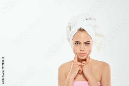 woman holding face with towel on head clean skin dermatology