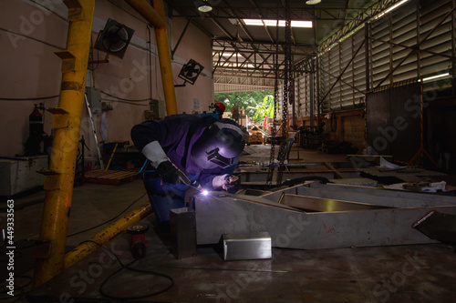 Skillful welders weld steel in the factory. Construction site metal welder. builder wear fireproof gloves for safety at work.