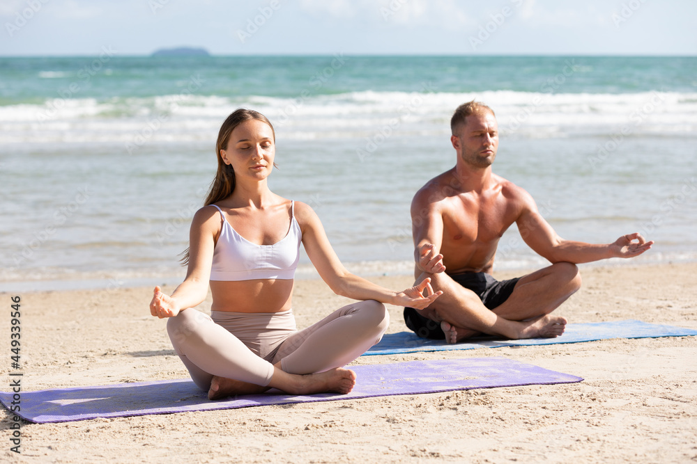 couple practicing meditation exercises on the beach couple practicing meditation exercises on the beach