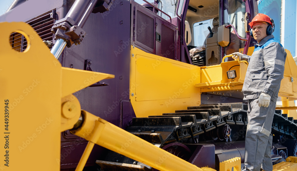 Industrial bulldozer driver gets into coal loading cab in open pit mine