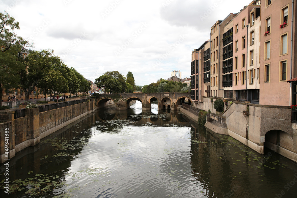 Naklejka premium Metz, France. Buildings on the banks of the Moselle river and the old bridge