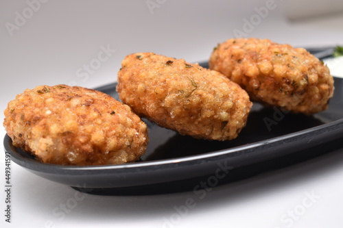 Close up shot of sabudana wada or shabudana vada in black dish with white background