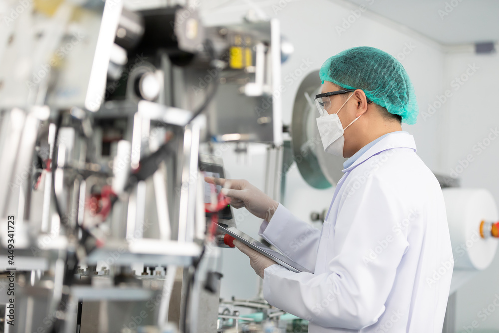 factory worker using tablet computer for finding how to use machine control panel in factory
