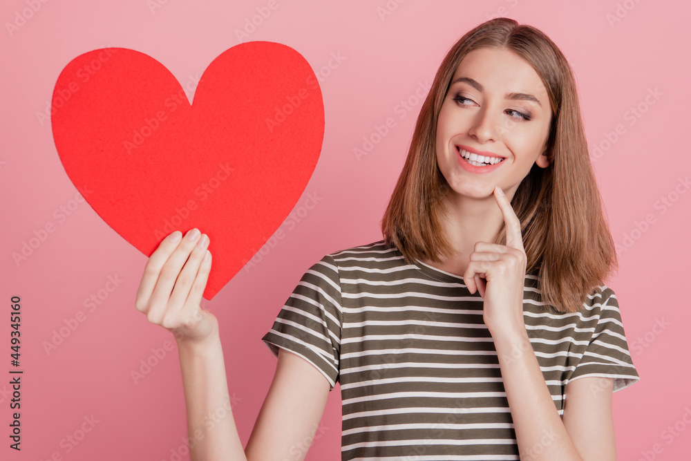 Portrait of cunning girlish flirty lady presenting red heart symbol on pink background Portrait of cunning girlish flirty lady presenting red heart symbol on pink background