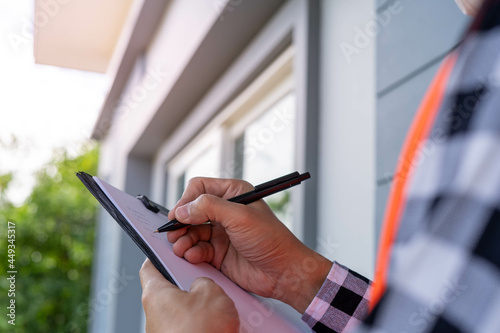 ..Inspector or engineer is checking and inspecting the building or house by using checklist. Engineers and architects work on building the house before handing it over to the landlord. photo