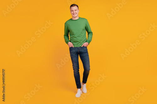 Portrait of confident guy hands pockets toothy white smile posing on yellow background