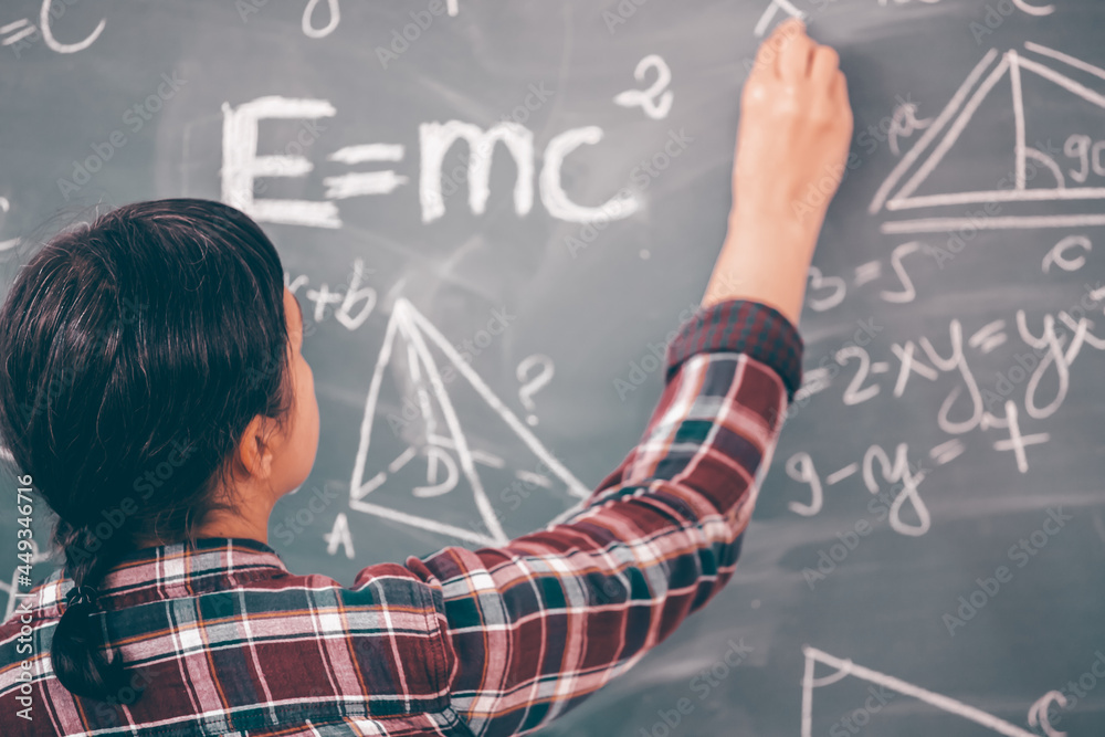 Teacher or student writing on blackboard during math lesson in school classroom Teacher or student writing on blackboard during math lesson in school classroom