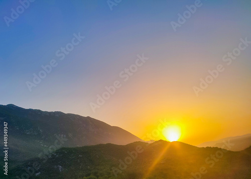 Sunset in mountains.Mountain valley during sunrise. Natural summer landscape.Colorful sunset on top of mountain.Sunrise in forested mountain © Oleh Gumennyi